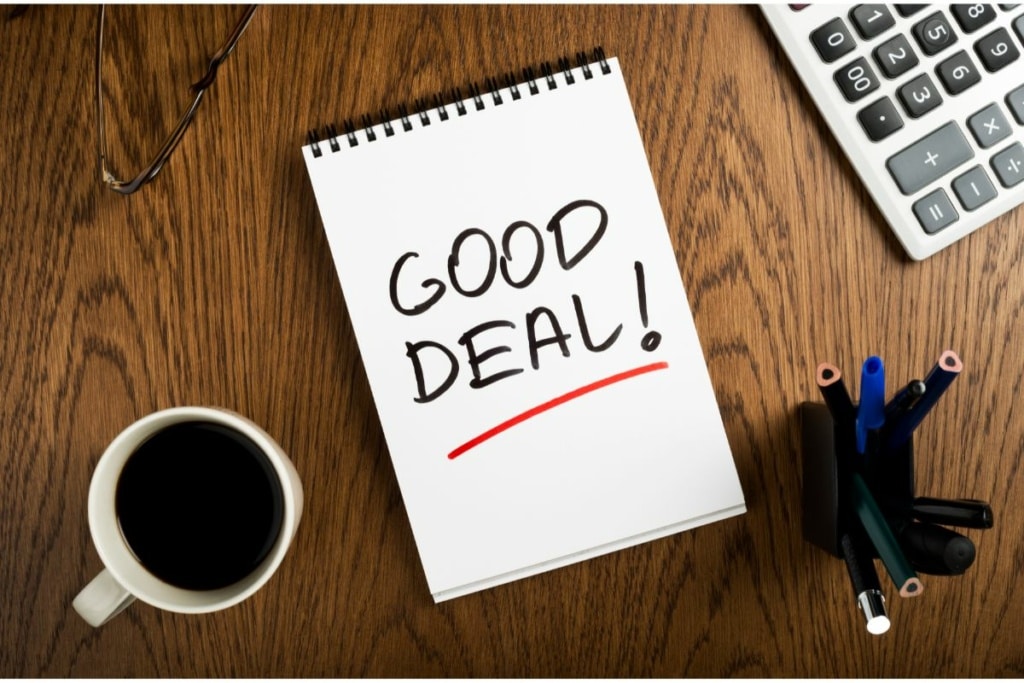 Carnet avec l'inscription "Good Deal" posé sur un bureau