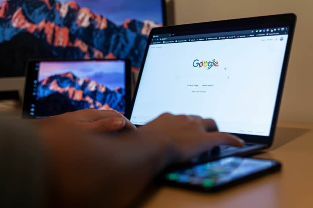 Mains sur clavier d'ordinateur portable. Page d'accueil Google