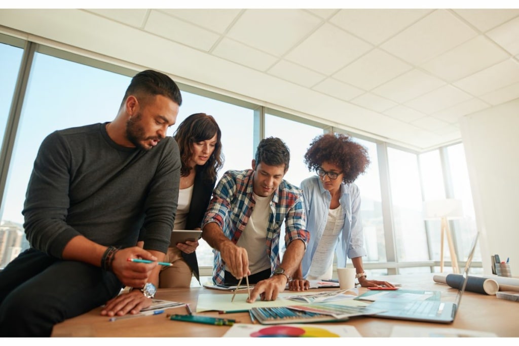 Quatre personnes travaillent sur un bureau