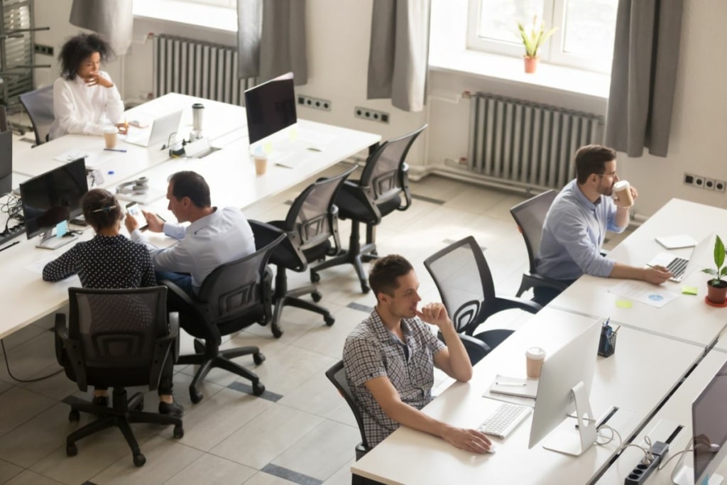 Plusieurs personnes travaillent sur ordinateur dans un open space