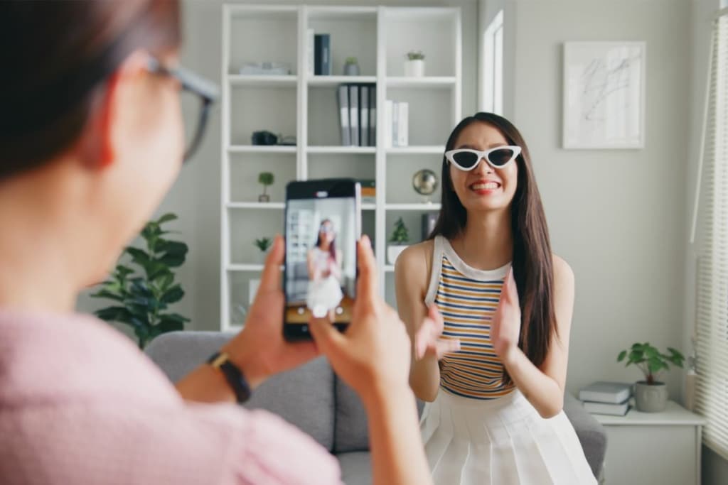 Un homme filme une femme avec son téléphone pour créer du contenu TikTok