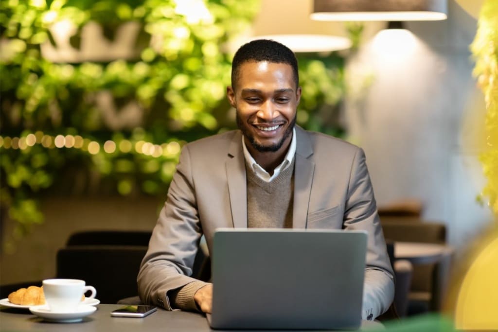 Homme souriant qui travaille sur un ordinateur portable