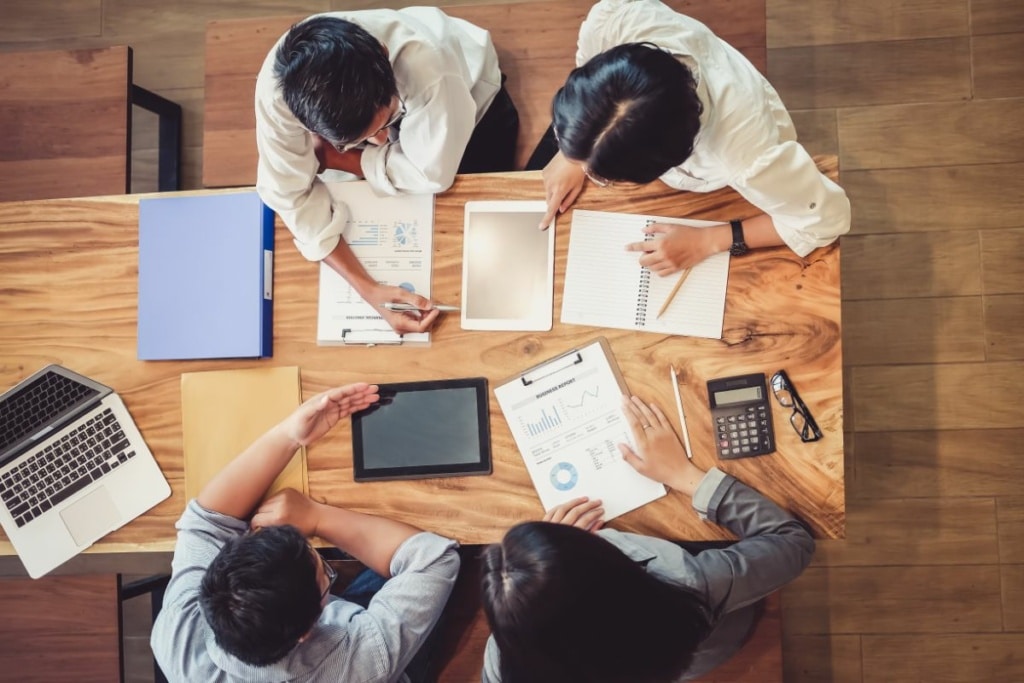 Quatre personnes travaillent autour d'un bureau