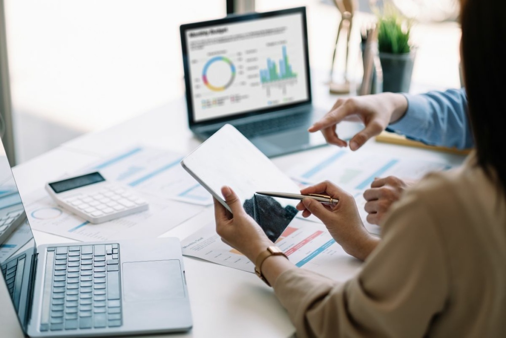 Deux personnes analysent des données sur un bureau.