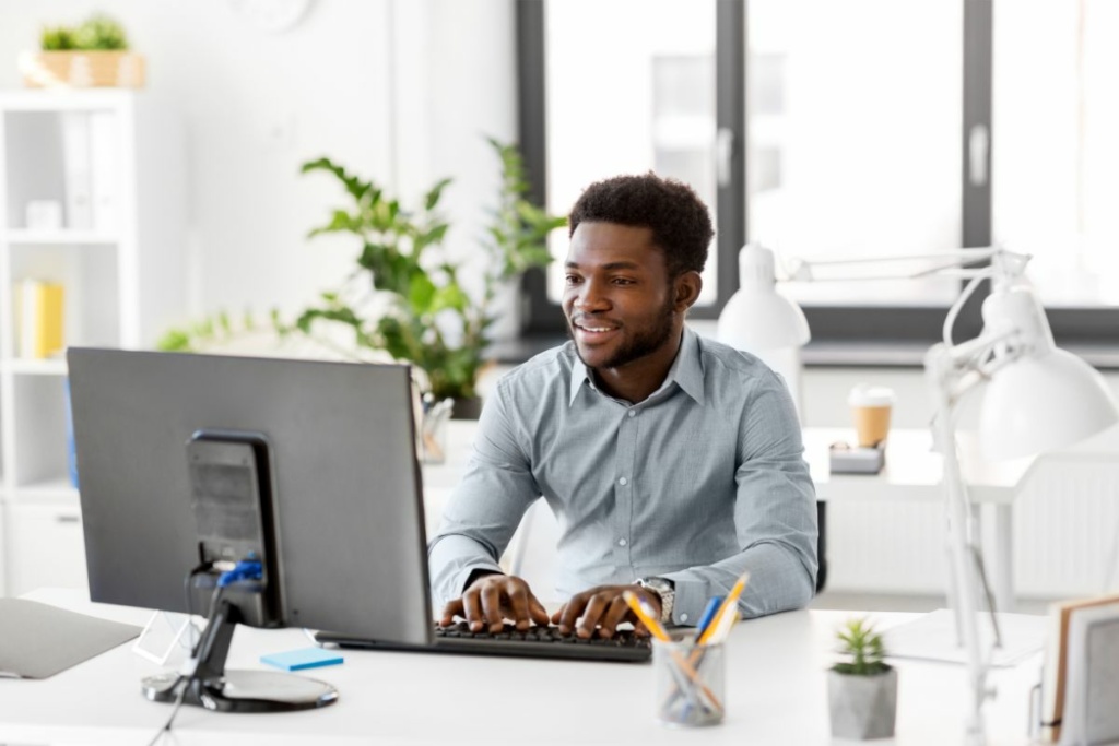 Un homme au bureau devant son ordinateur.