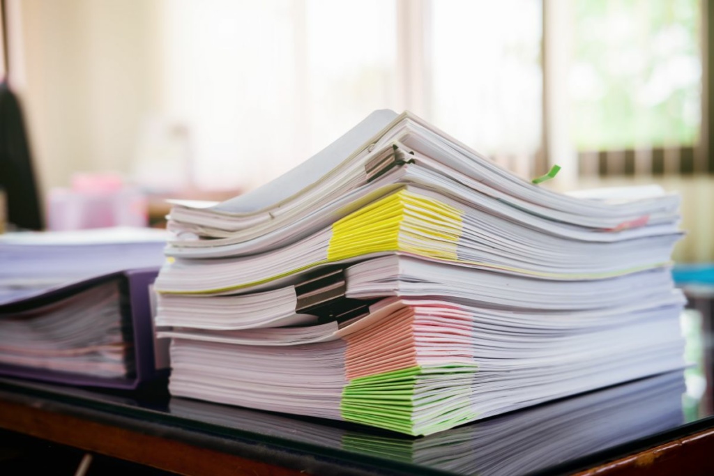 Pile de documents posée sur un bureau.