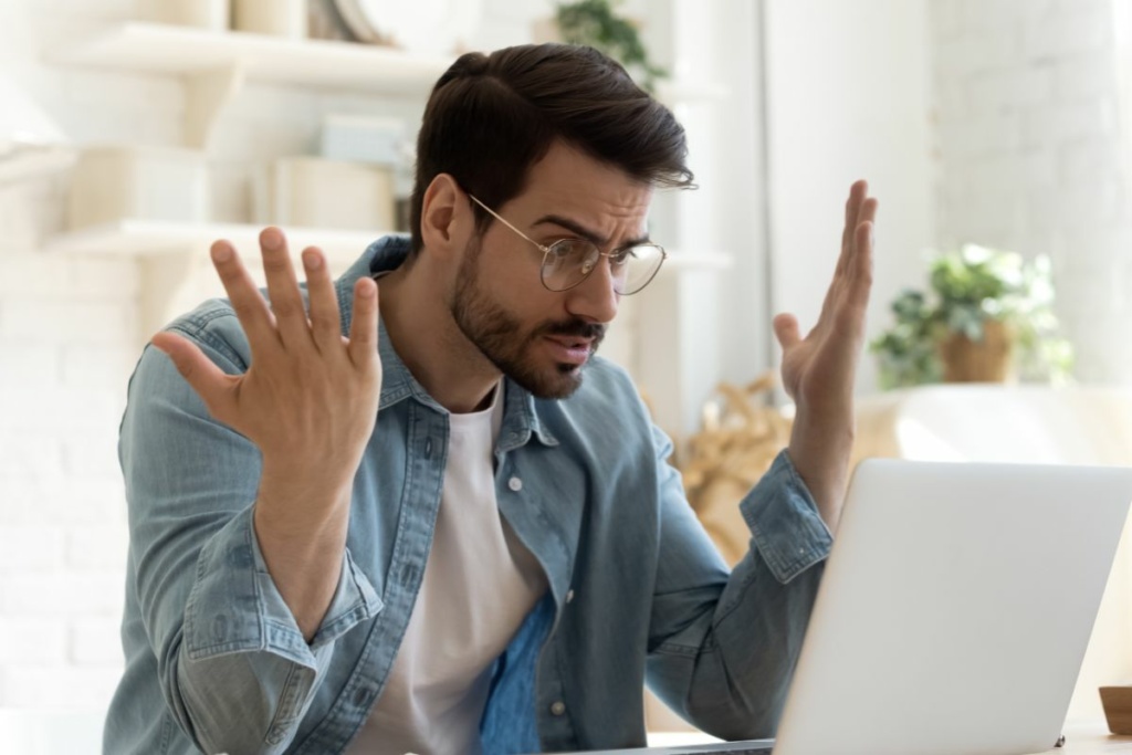 Un homme s'énerve devant un ordinateur.