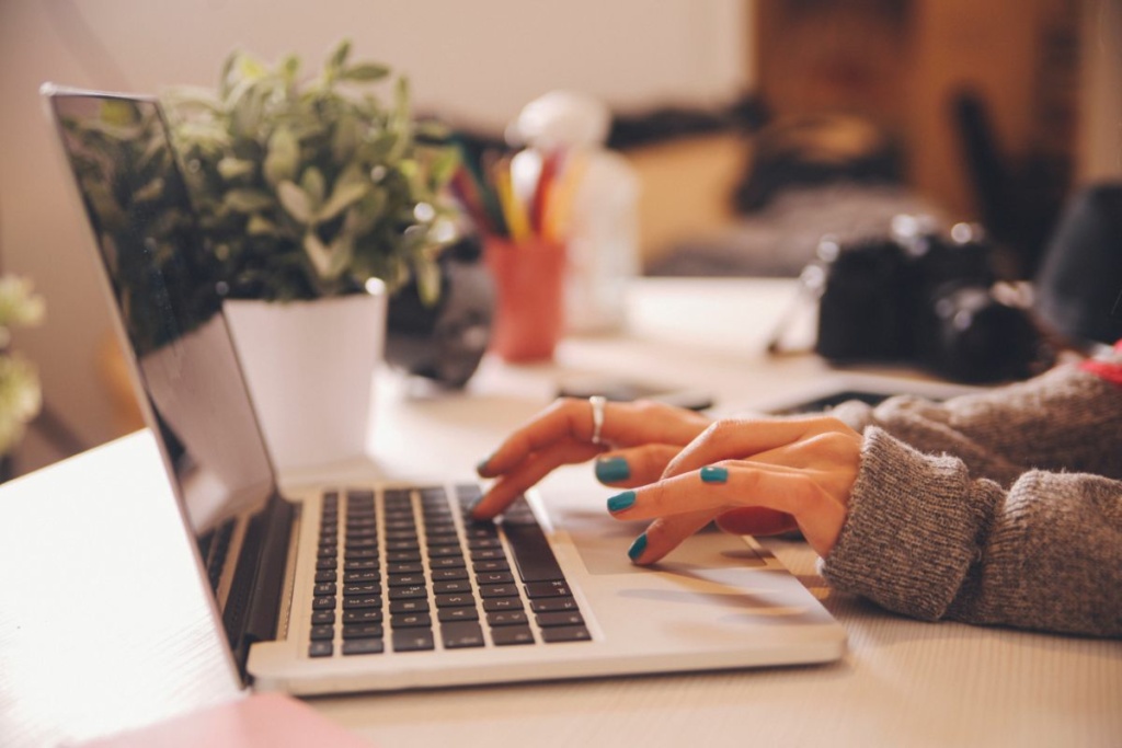 Mains de femme qui utilisent un ordinateur.