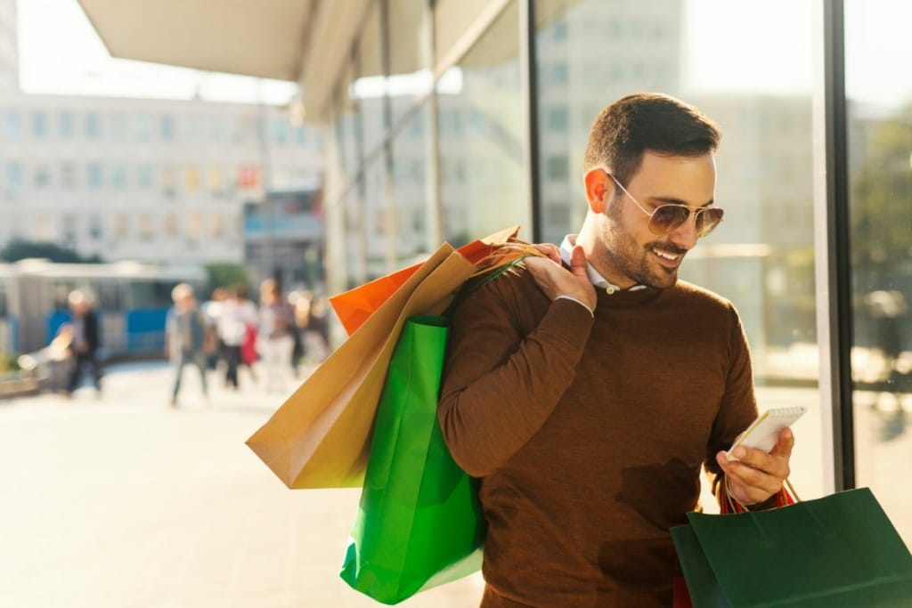 Un homme porte des sacs de shopping.